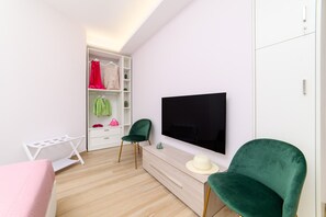 A modern bedroom with a bed, a TV, a wardrobe, and a desk. - Domus Sirenum (Sorrento)