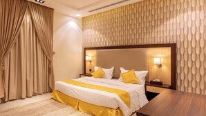 Ein modernes Hotelzimmer mit einem großen Bett, einem hölzernen Kopfteil und einer Wand mit Muster.