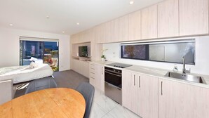 A modern kitchen with a dining area, built-in appliances, and a large window.