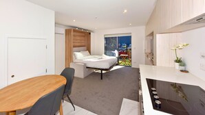 A modern bedroom with a bed, a desk, and a chair.