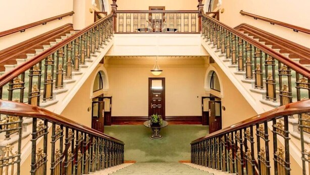 A grand staircase with ornate railings and a central landing area.