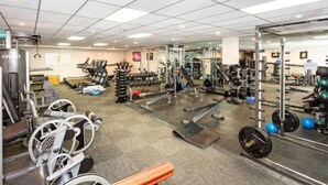 A gym with various exercise equipment, including treadmills, weight machines, and free weights.