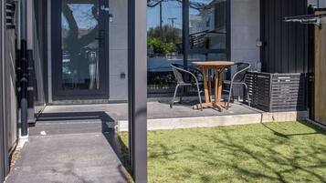 A modern building with a covered patio area, a number 9 sign, and a small table with chairs.