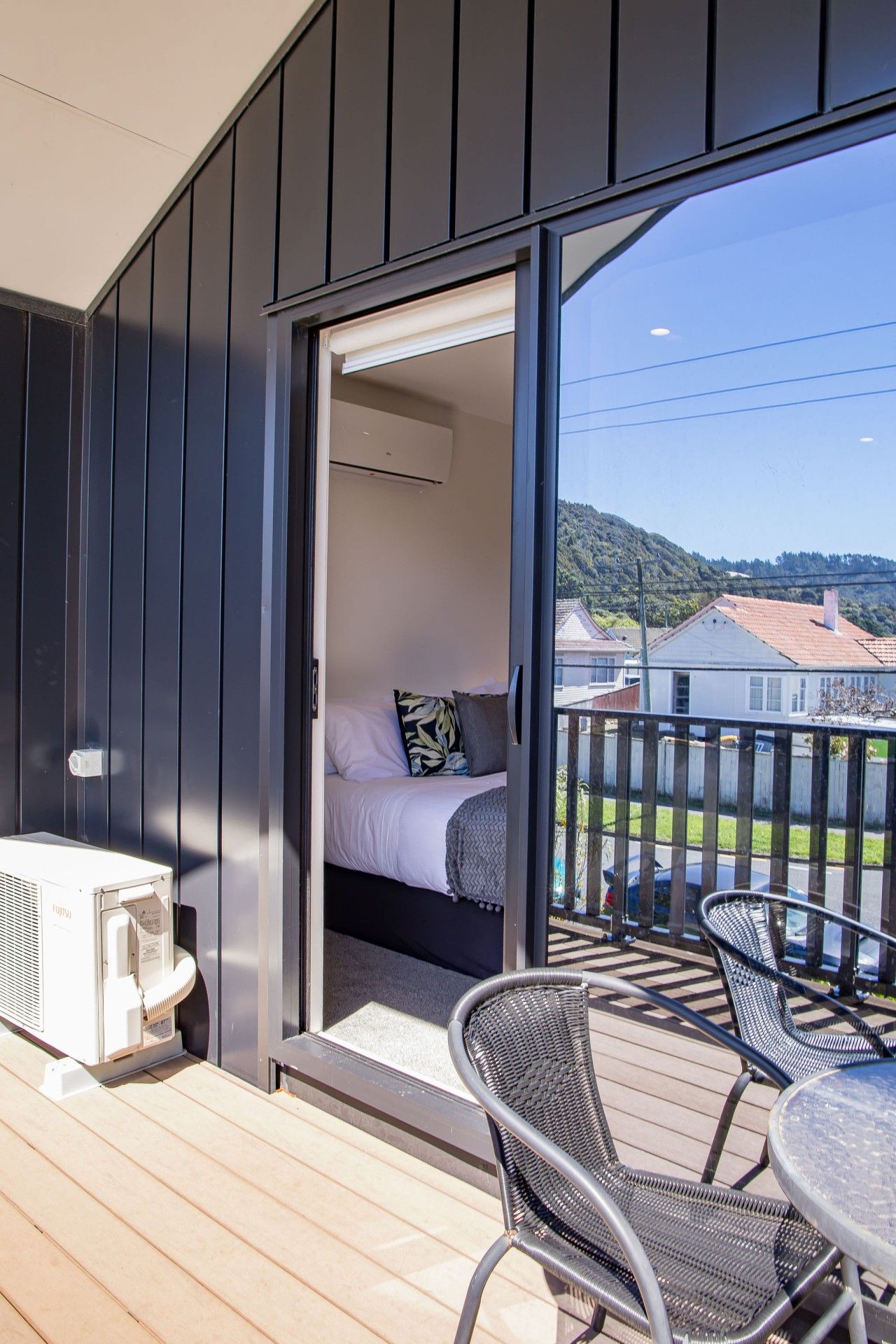 A balcony with a bed, a table, and chairs.