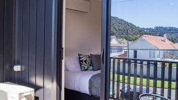 A balcony with a bed, a table, and chairs.