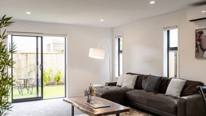 Un salon moderne avec un canapé en cuir marron, une table basse en bois et un lampadaire.
