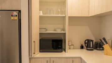 Une cuisine moderne avec des meubles en bois, un appareil à café intégré et un réfrigérateur en acier inoxydable.