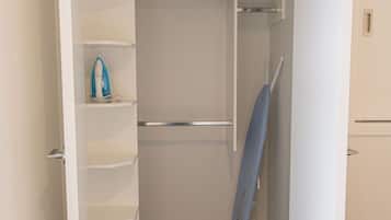 A walk-in closet with shelves, a hanging rod, and a folded item on the floor.