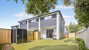A modern two-story house with a fenced backyard, a small shed, and a well-maintained lawn. - Bright and Comfortable 2BR Stay on Rainey Grove (Lower Hutt)