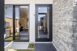 A modern building with a stone facade and a glass door entrance. - Ariki Shire: A Wellington Fantasy (Lower Hutt)