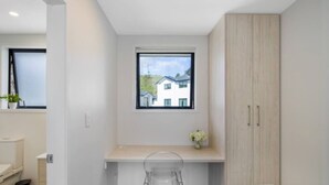 A small, modern bathroom with a window, a toilet, and a shower area. - Staycation Treasure at Johnston (Lower Hutt)