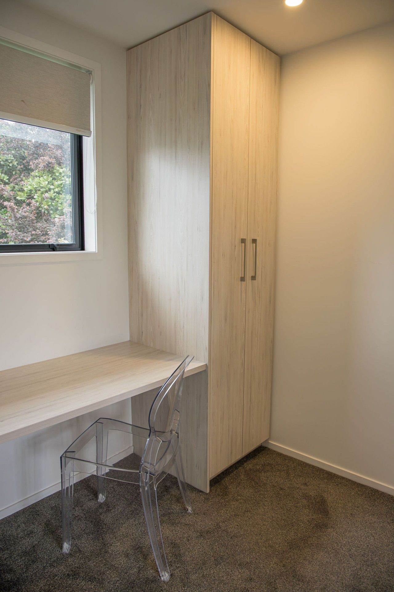Een hoekappartement met een ingebouwde bureau, een stoel en een kledingkast.