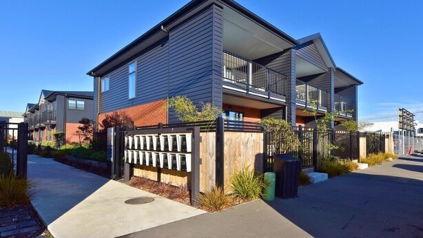 A modern residential building with a flat roof, large windows, and a gated entrance. - Charming CBD Studio Apartment (Christchurch)
