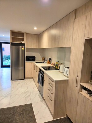 Eine moderne Küche mit einem integrierten Kühlschrank, einer Mikrowelle und einem Toaster.