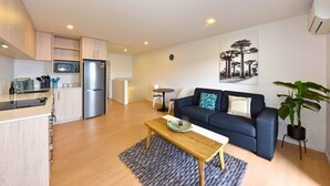 A modern apartment with a kitchen, dining area, and living room. - Spacious CBD 1-Bed 1-Bath (Christchurch)