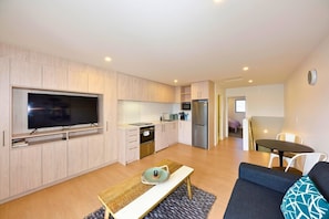 A modern apartment with a kitchen, dining area, and living room.