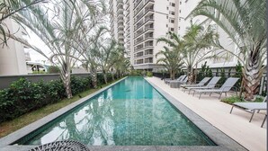A swimming pool with lounge chairs and palm trees, surrounded by high-rise buildings. - Fully equipped studio WiFi, AC Sao Paulo metro Sacoma Paulista Congonhas Airport (São Paulo)