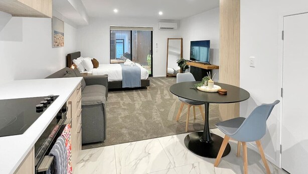 Un apartamento moderno con cocina, comedor y un dormitorio.