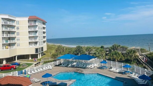 A hotel with a pool, beach view, and a parking area. - 2-bedroom condo in gorgeous North Topsail Beach with WiFi, AC viewing the ocean (North Topsail Beach)
