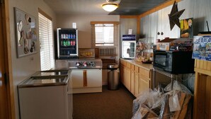 A compact kitchen with a refrigerator, stove, and a beverage cooler. - Family-Friendly Cabin with Fire Pit, BBQ, Picnic Area, and Free Parking (Cañon City)