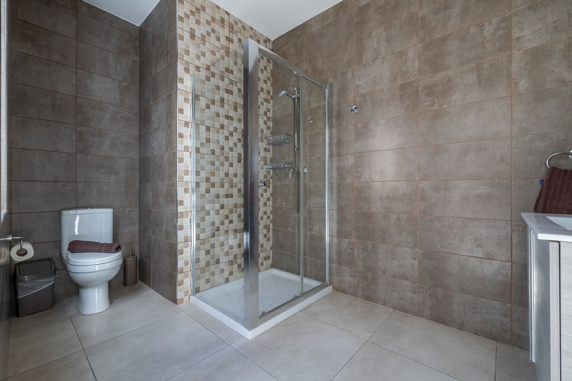 Une salle de bain moderne avec une douche à parois de verre, des toilettes et un lavabo.