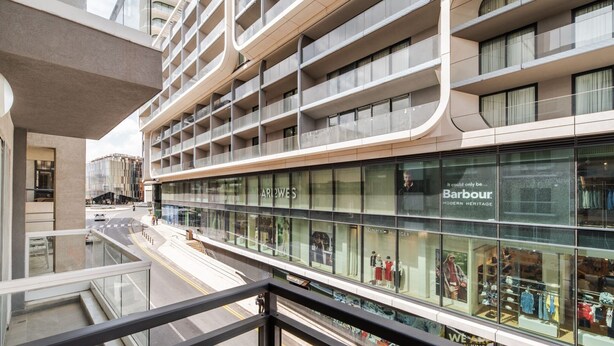 A multi-story hotel with a modern design, featuring a glass facade and a visible retail store on the ground floor. - Stylish 2BR Escape in St Julians (Saint Julian's)
