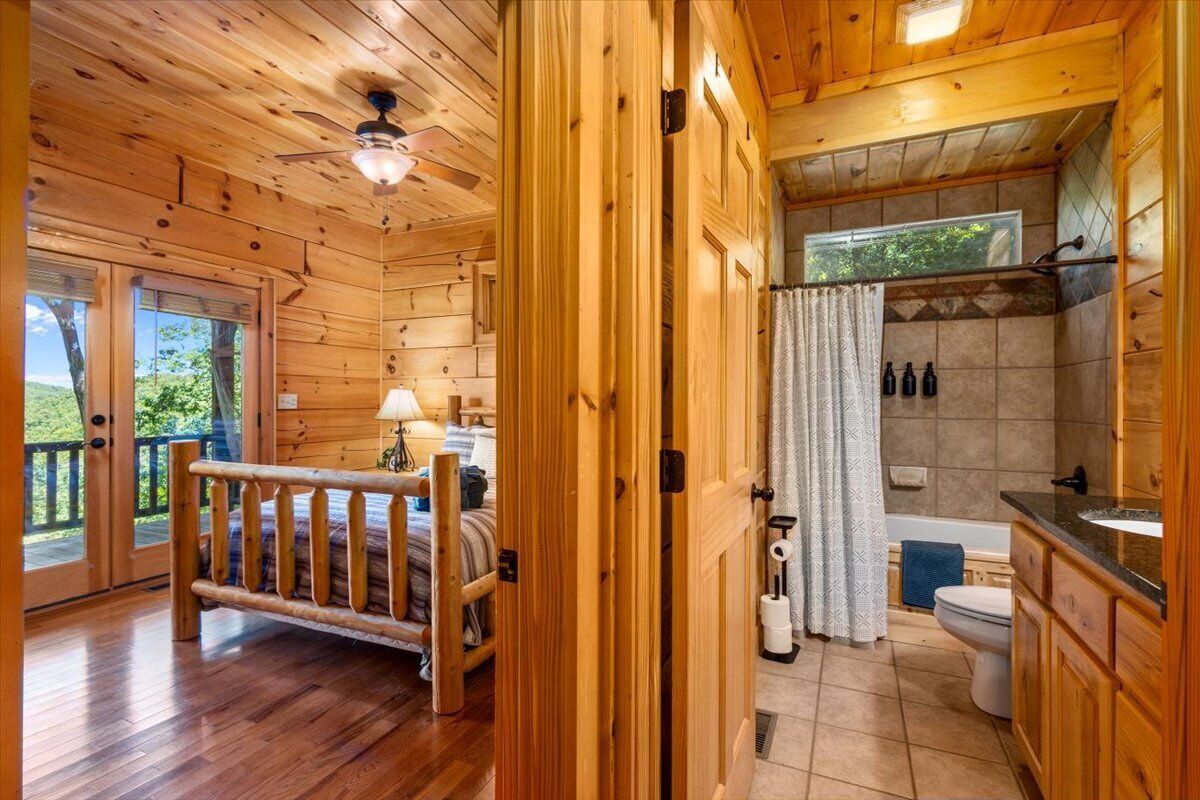 Ein Holzblockhaus mit Bett, Bad und Balkon.