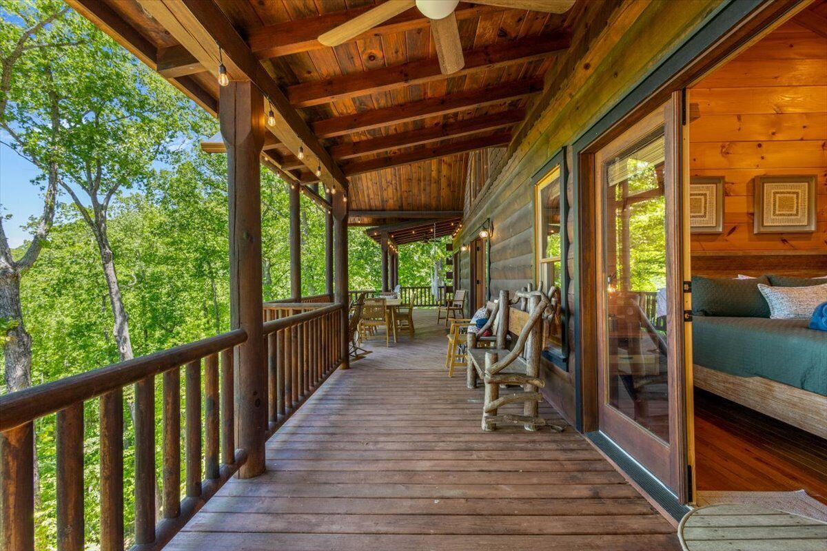 Eine Holzterrasse mit Geländer, einer Sitzecke und einem Tisch mit Stühlen.