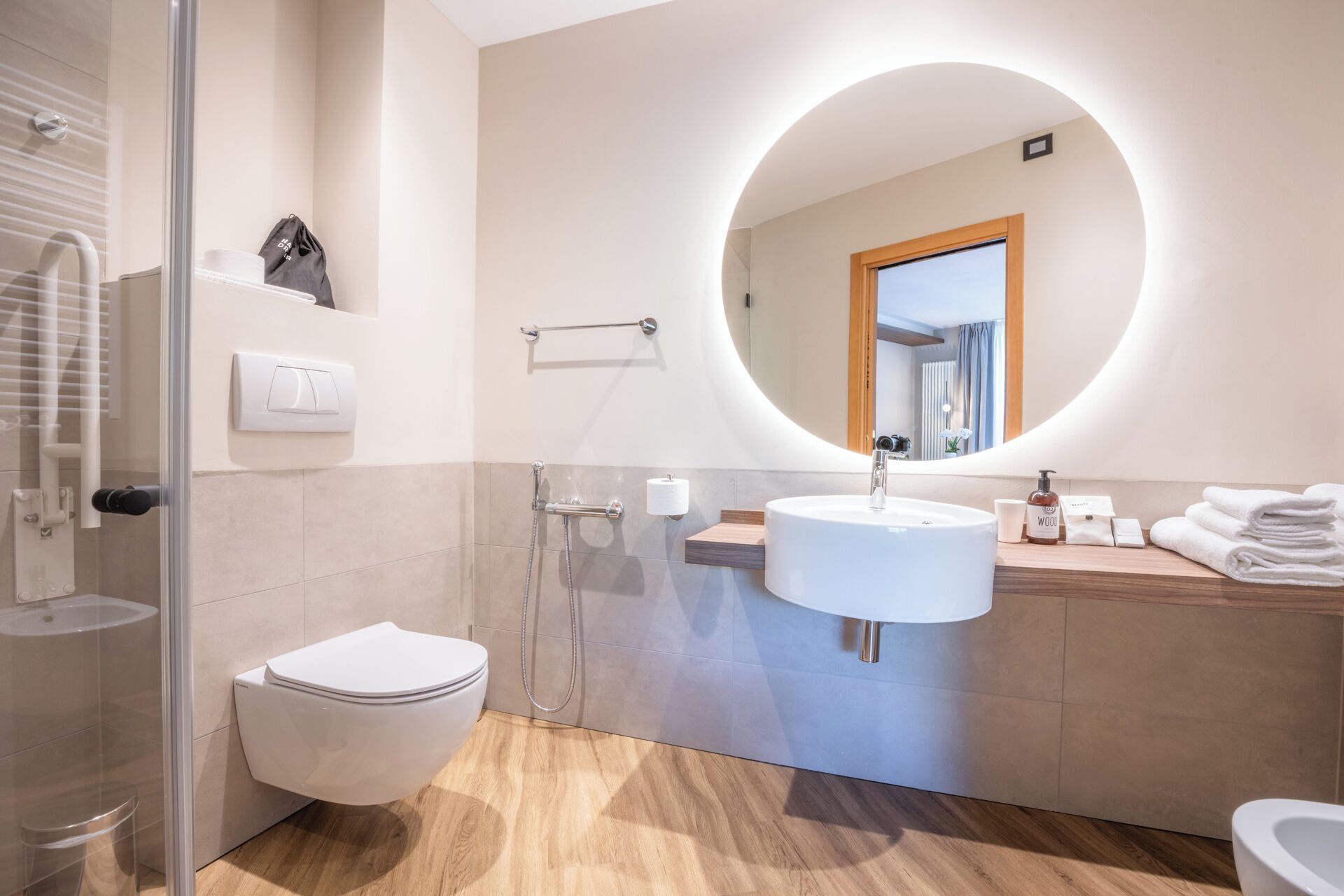 Uma casa de banho moderna com sanita, lavatório e chuveiro.