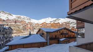 Une ville de montagne enneigée, avec des bâtiments en bois et un ciel dégagé.