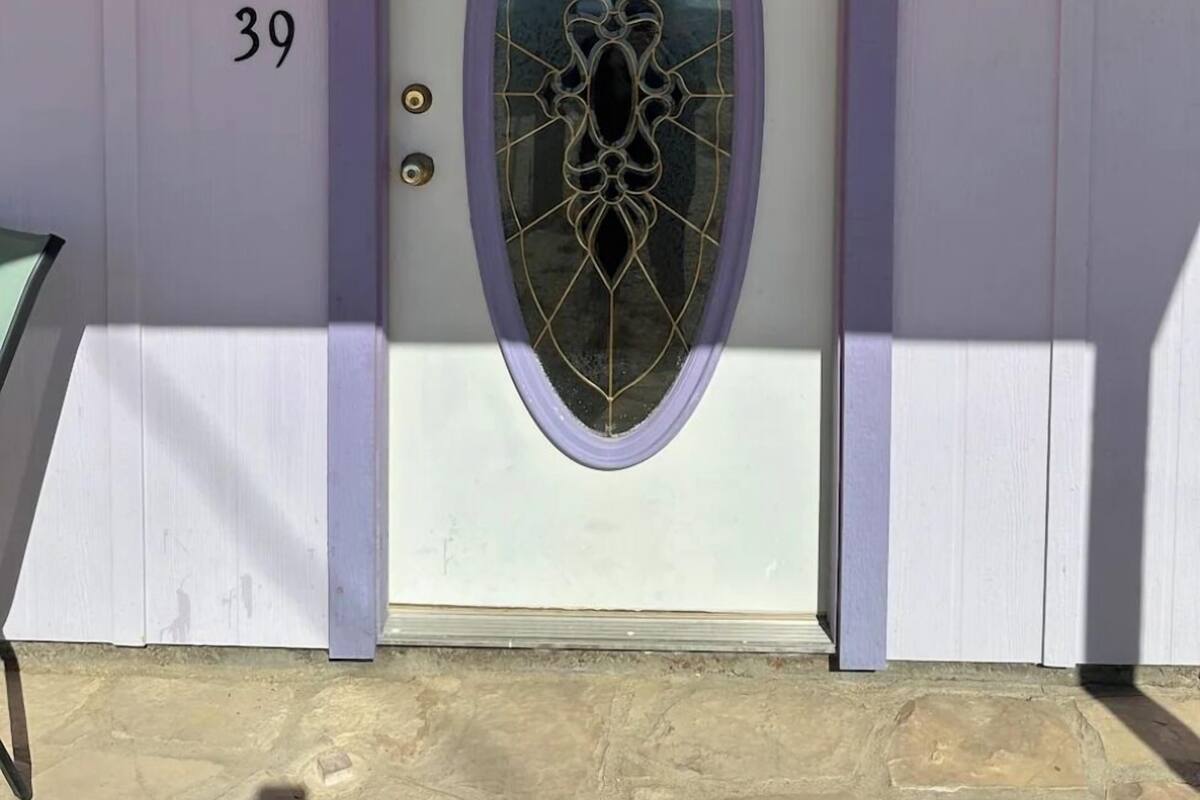 A house with a white door featuring a purple frame and a decorative glass panel. The number '39' is visible on the door.