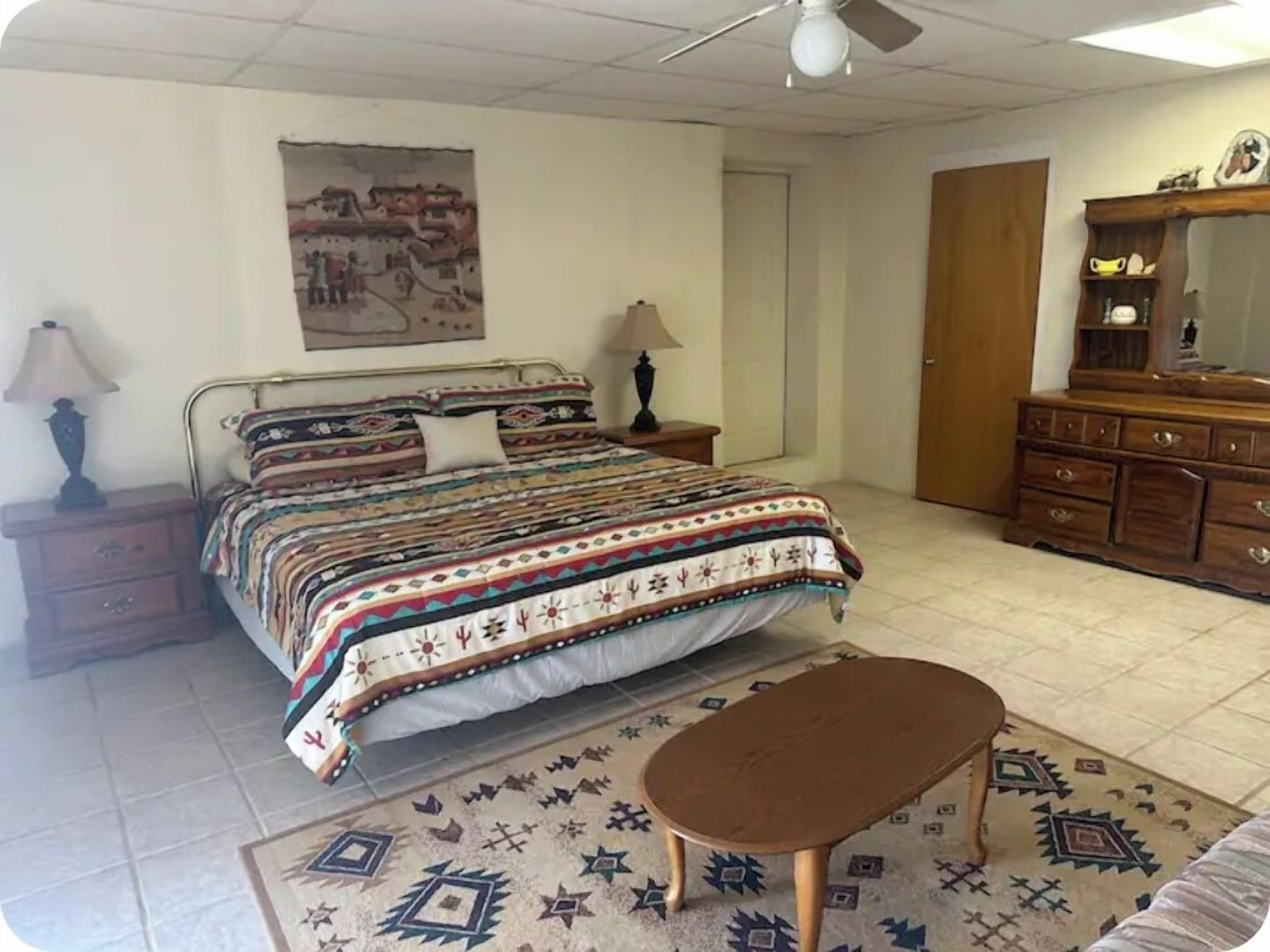Une chambre à coucher comprenant un lit, une table de chevet, une commode et un banc.