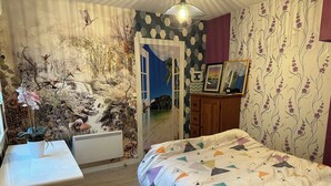 Une chambre à coucher avec un lit, une commode et une fresque murale.