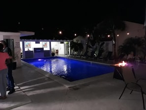 Una piscina al aire libre, sillones reclinables de piscina