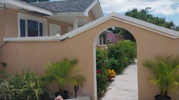 A house with a covered entrance, potted plants, and a gravel driveway.