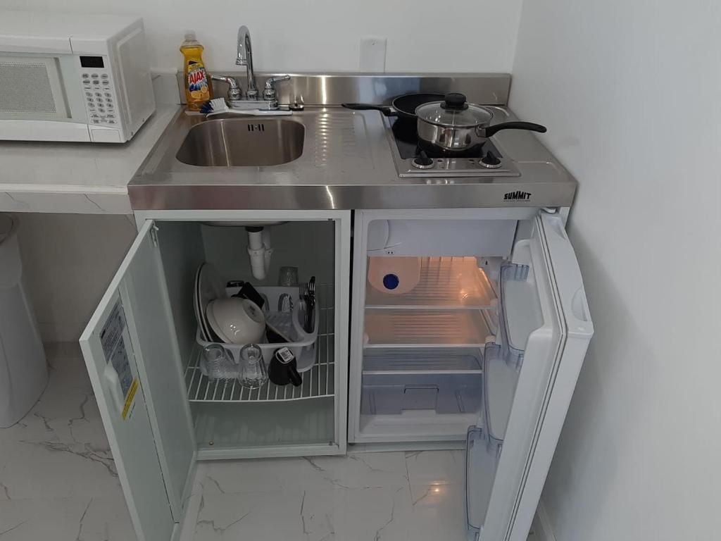 A compact kitchen with a built-in microwave, a sink, and a stove.