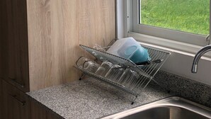 Een keuken met een granieten aanrecht, een roestvrijstalen spoelbak en een afwasschaal.