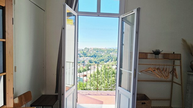 A room with an open door leading to a balcony with a city view. - Apartment: Les Senteurs de Grasse (Grasse)