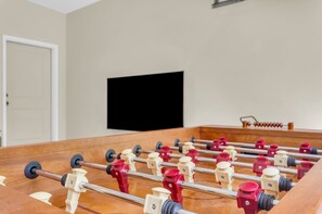 A foosball table in a room with a white wall and a closed door. - 3 Min to Downtown, Game Room, King bed (Greenville)