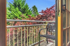 A balcony with a metal railing, a wooden deck, and a bench. - 3 Min to Downtown, Game Room, King bed (Greenville)