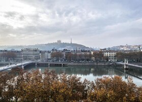 Un paisaje urbano con un río, edificios y un puente.