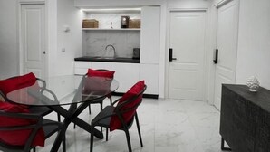 A modern kitchen with white cabinets, a marble countertop, and a built-in oven. - Napoli Heart and Suite (Naples)
