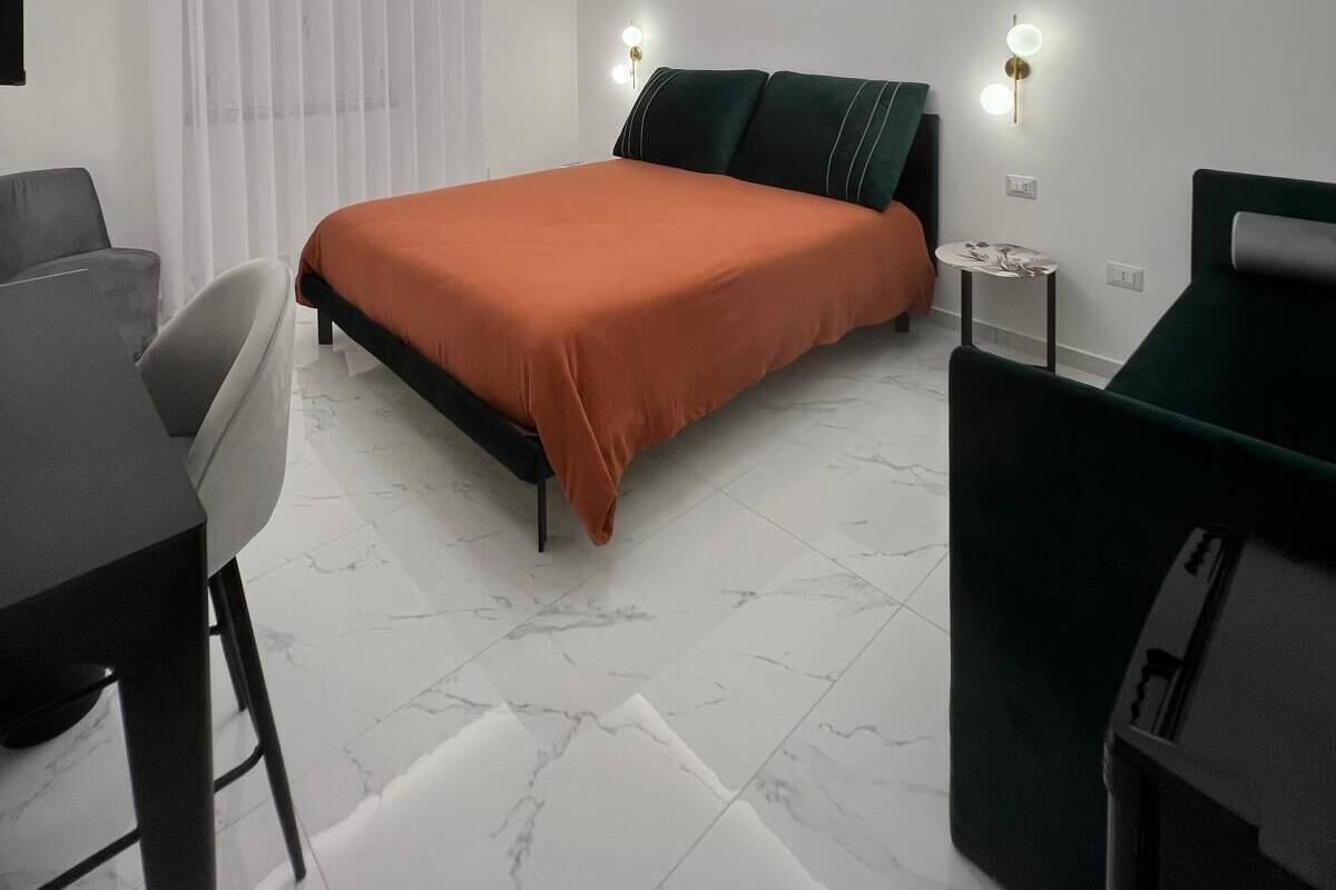 Ein modernes Schlafzimmer mit Bett, Schreibtisch und Stuhl.
