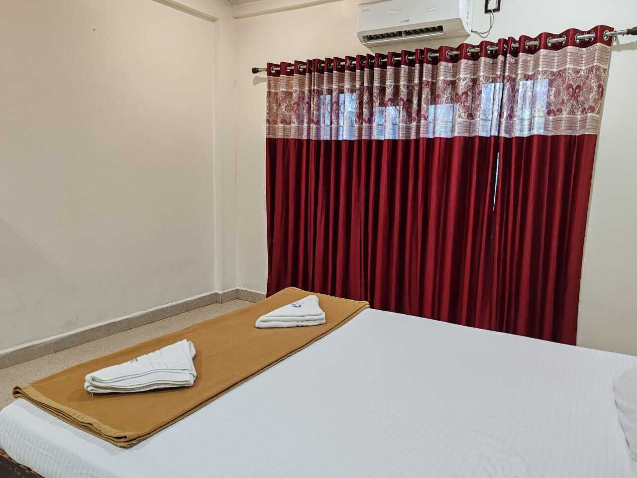 Een hotelkamer met een bed, een bruine handdoek en een wit kussen.
