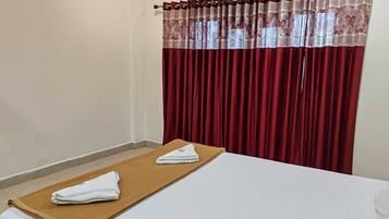 Een hotelkamer met een bed, een bruine handdoek en een wit kussen.