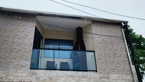 A building with a balcony, a window, and a brick facade. - Perequê-Açú - 200m from the beach • Air conditioning • Grill • 8 Guests (Perequê-Acu Ubatuba)
