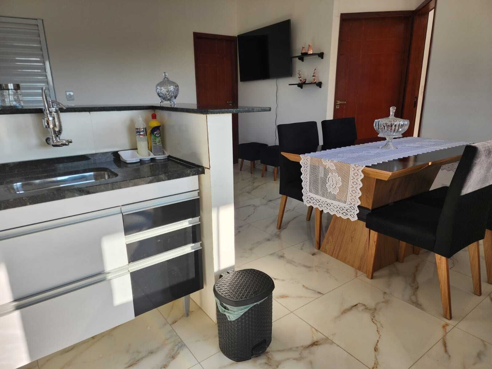 Una cocina moderna con un lavamanos, armarios y un comedor con una mesa y sillas.