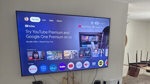 Un téléviseur à écran plat fixé au mur affiche une offre pour les abonnements YouTube Premium et Google One Premium.