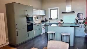 Eine moderne Küche mit einer zentralen Kochinsel, integrierten Geräten und einem Fenster über der Spüle.