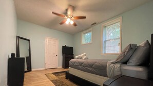 A bedroom with a bed, a dresser, a TV, a ceiling fan, and a window. - Chill Suburban 1BR Hideaway Near Truist Stadium (Mableton)
